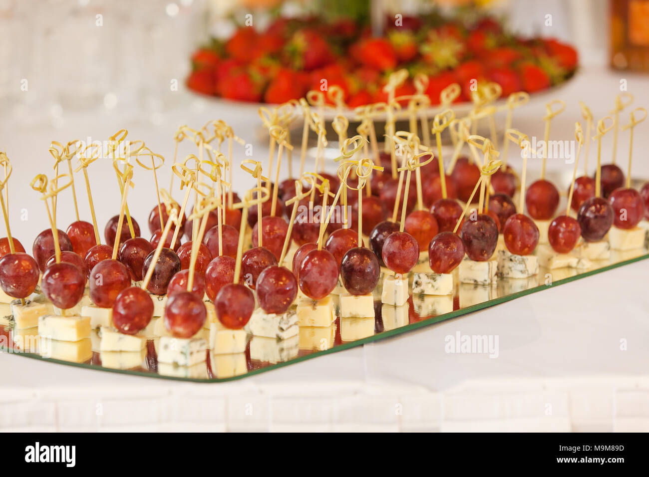 Rows of tasty mini canapes with brie cheese and grapes.Canape with