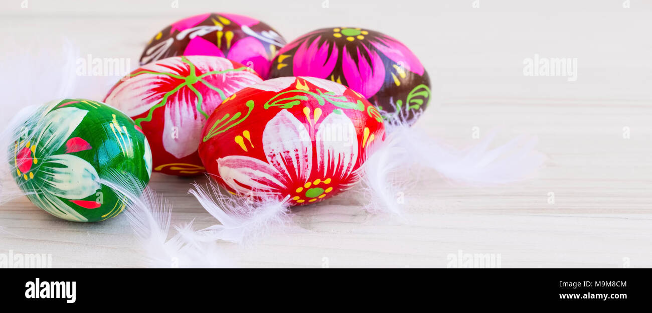 Easter eggs festive painted, decorative eggs with white feathers Stock Photo