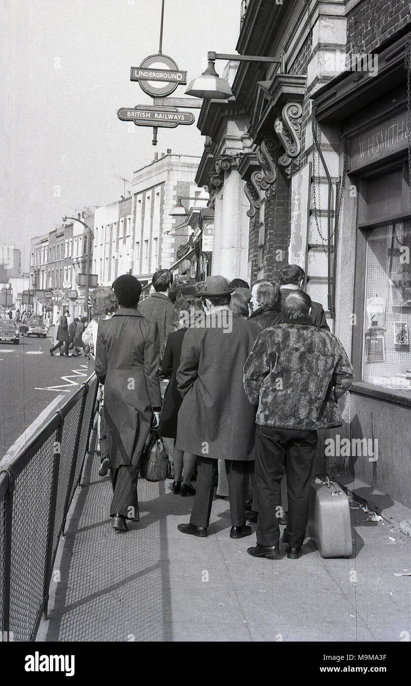 1970s, historical, rail passengers queuing up on the narrow pavement outside New Cross Railway station in South East London, England. At this time, strikes and cancelled trains were a common occurrence on British Rail and in this instance the platforms were too full to take more passengers. Stock Photo