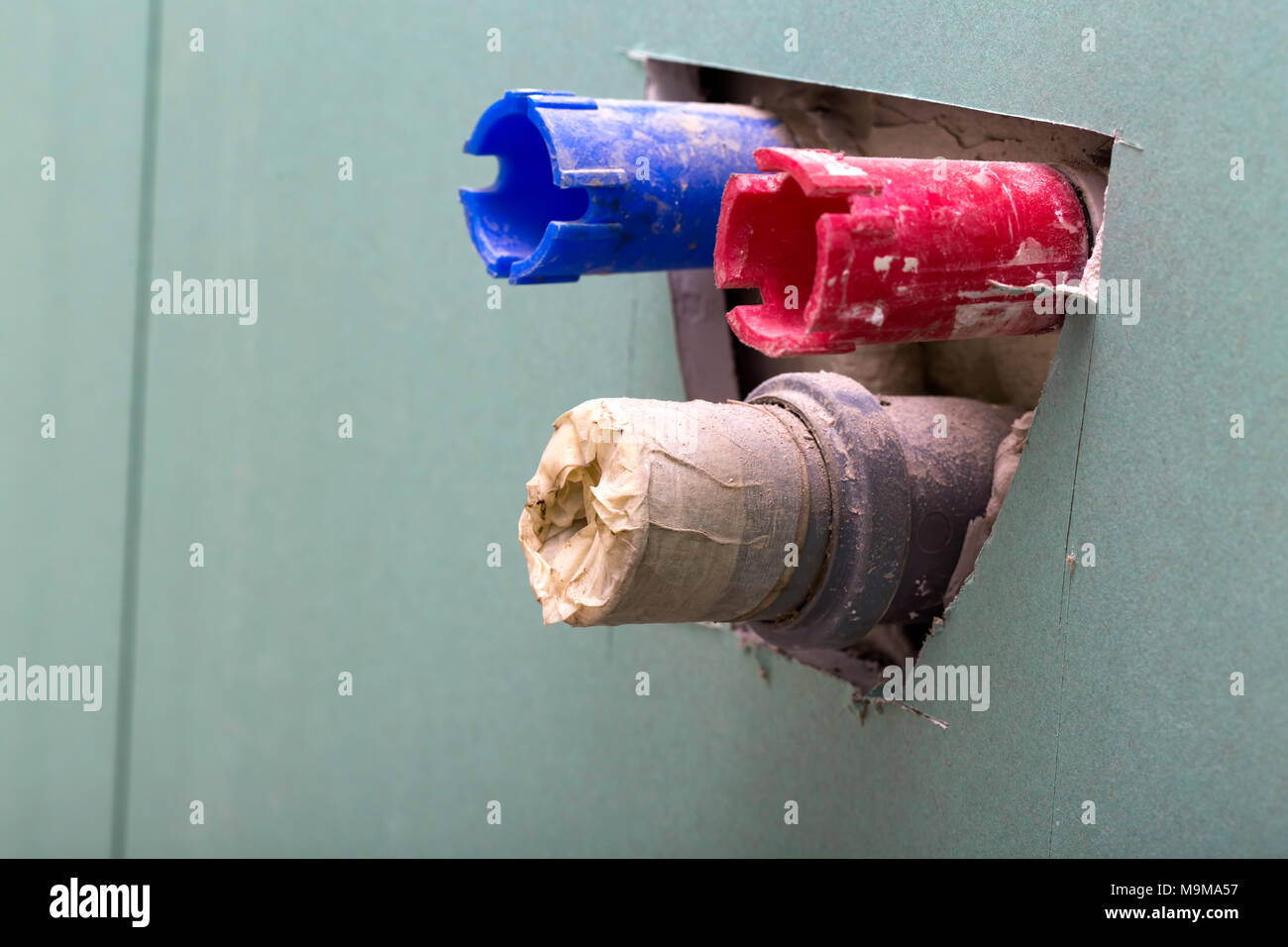 Pipes and plastic drain coming out of the wall ready for mounting a