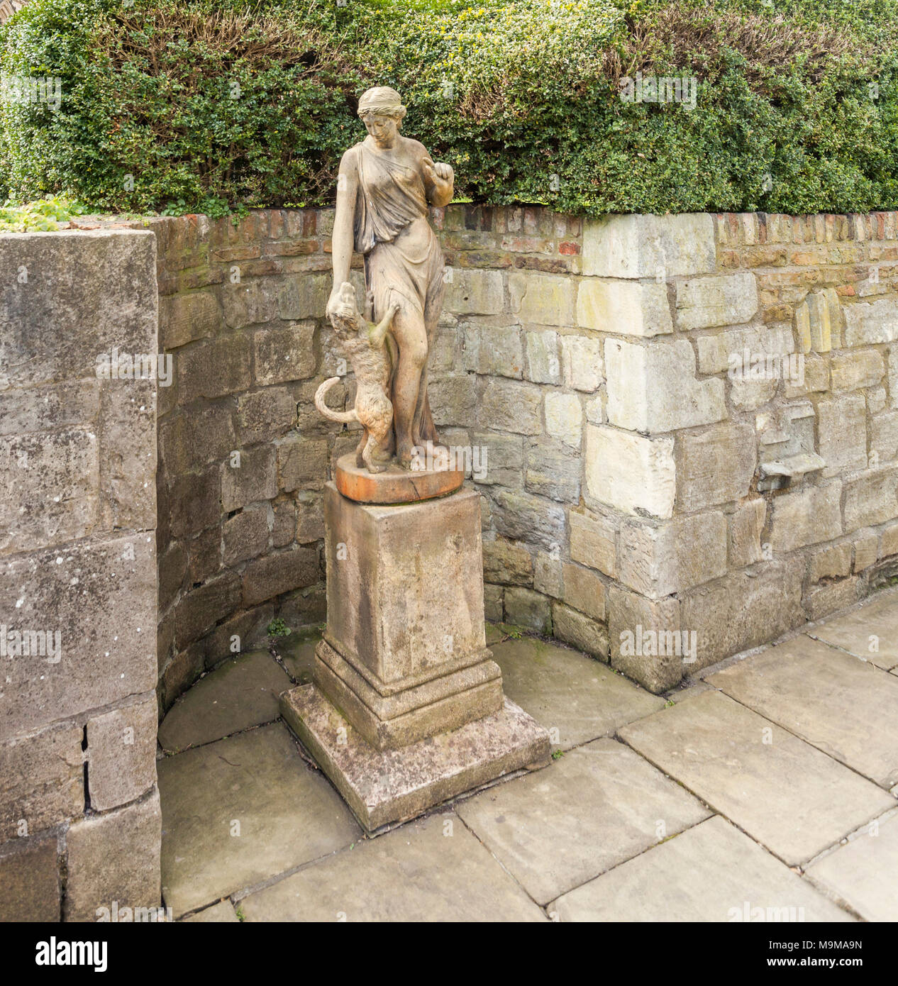 A statue of the  classical goddess, Fidelty and dog in the Treasurer's House gardens  in York,North Yorkshire,England,UK Stock Photo