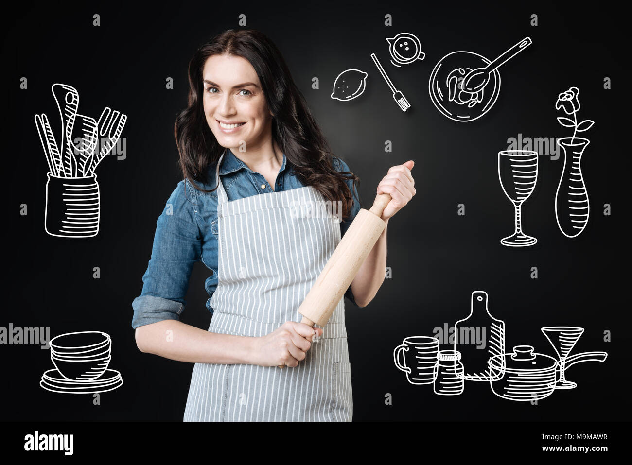 Smiling cook feeling confident while holding a rolling pin Stock Photo ...