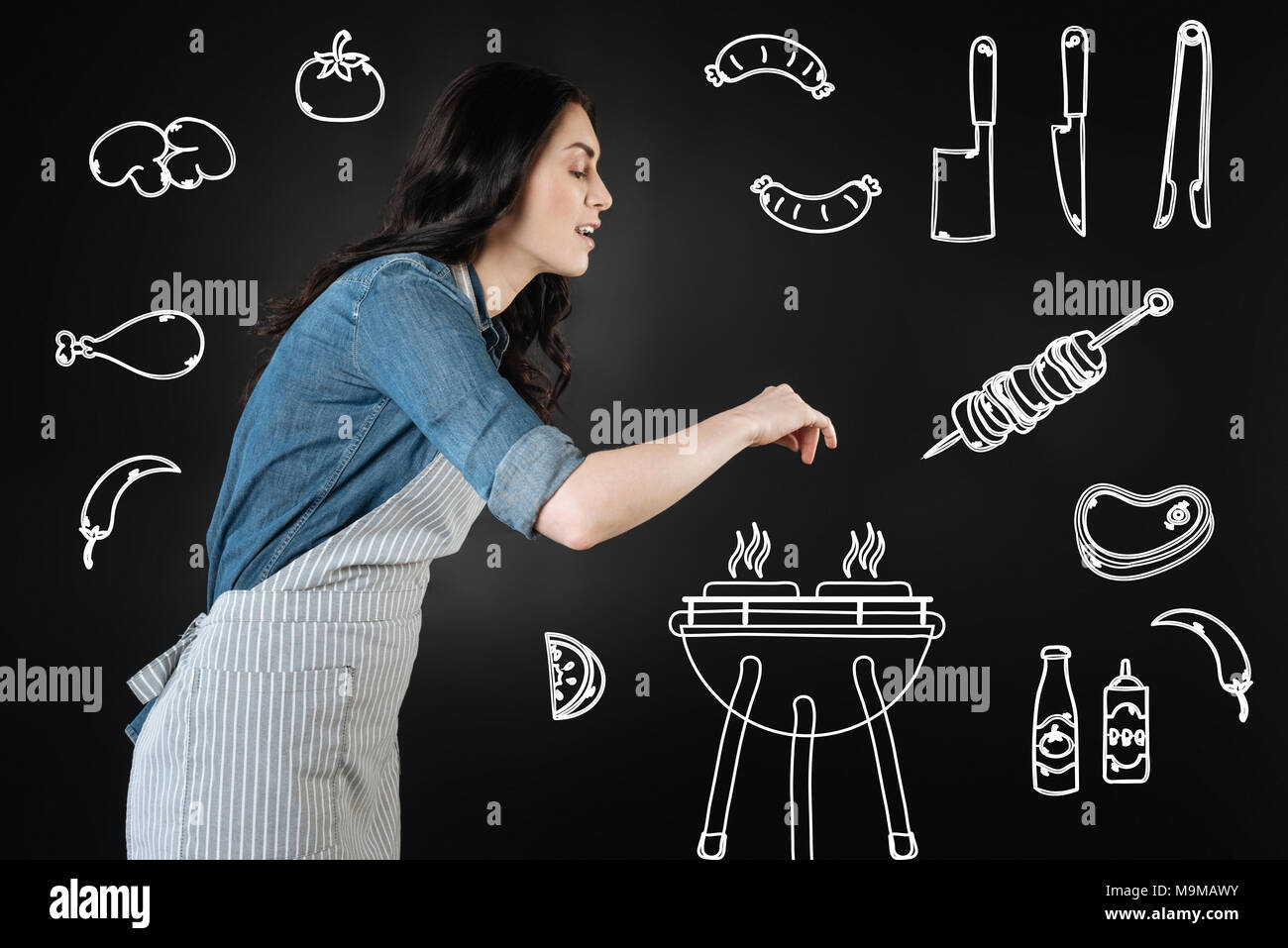 Smiling young woman adding spices while making barbeque Stock Photo