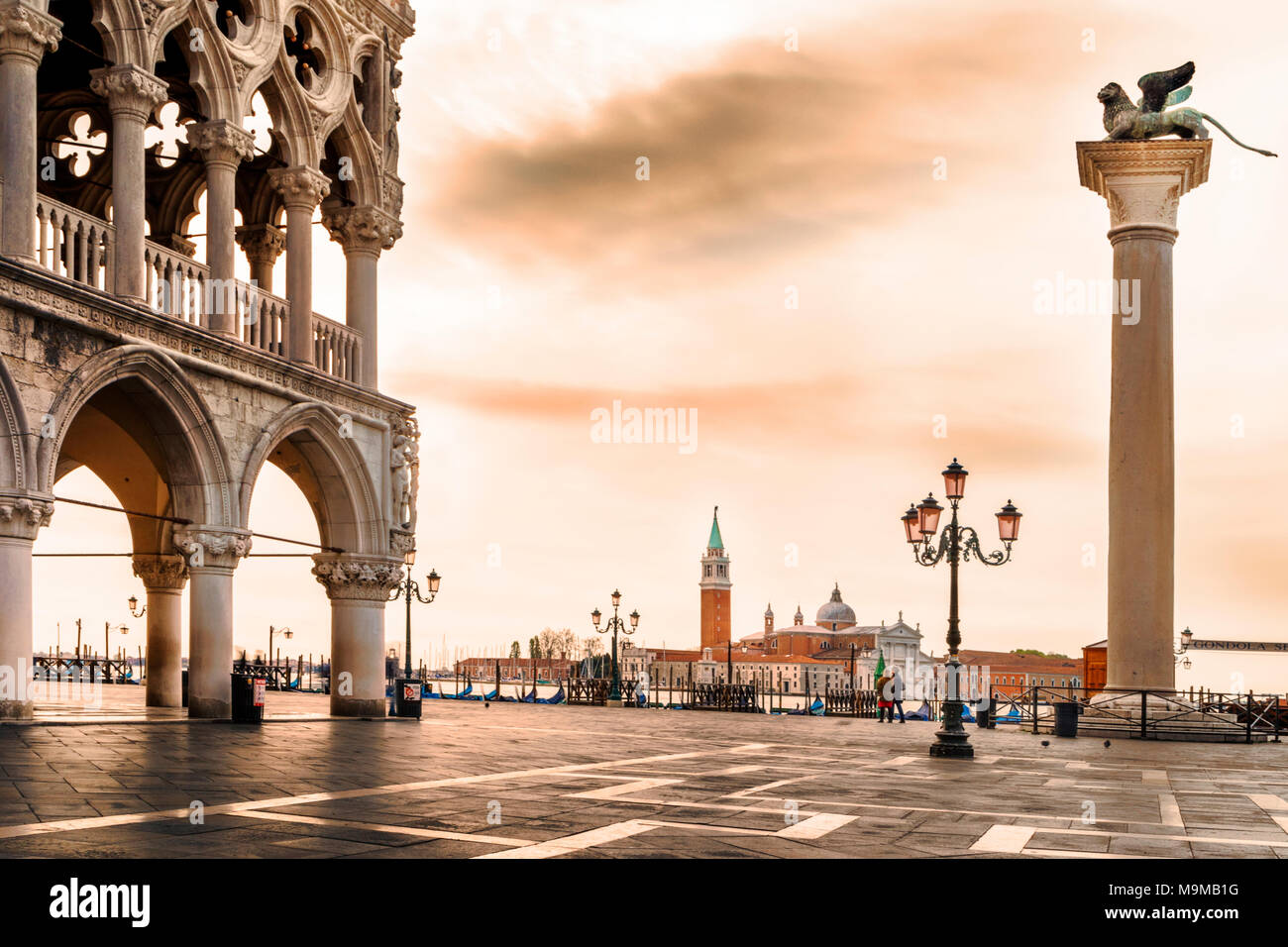 Piazzetta di San Marco, the South facade of St Mark's Basilica, showing arcade and columns of Doge's Palace, winged lion column, lamps and San Giorgio Stock Photo