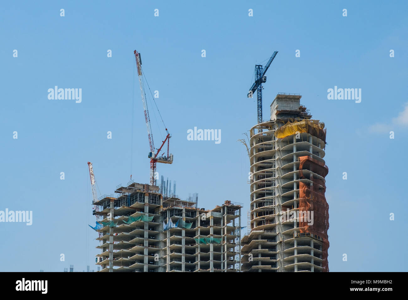 cranes on construction site  of new skyscraper building isolated - Stock Photo