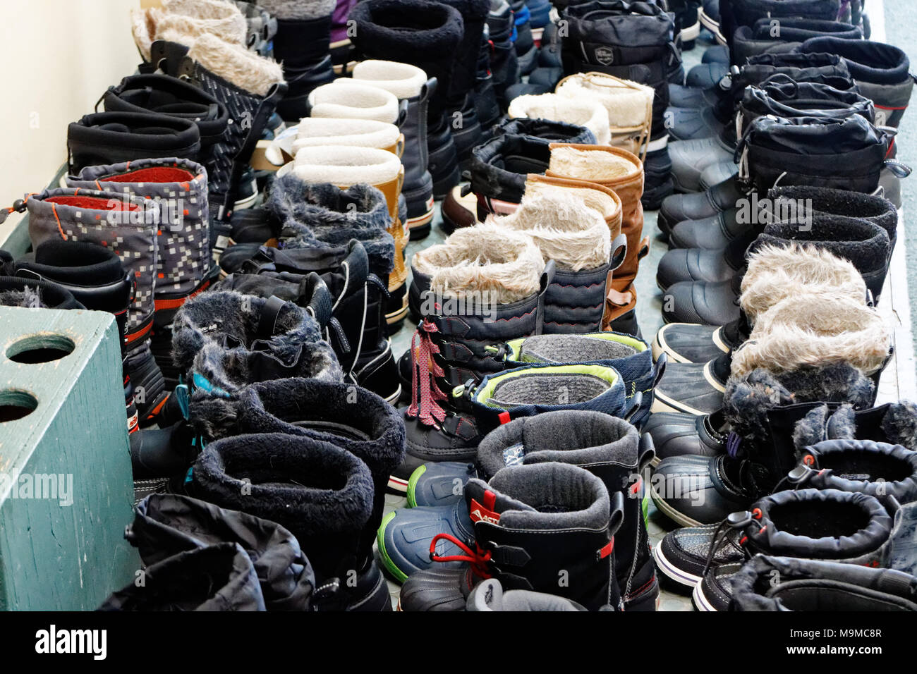 Sixty five pairs of winter boots neatly lined up in a Quebec cross country ski station Stock Photo