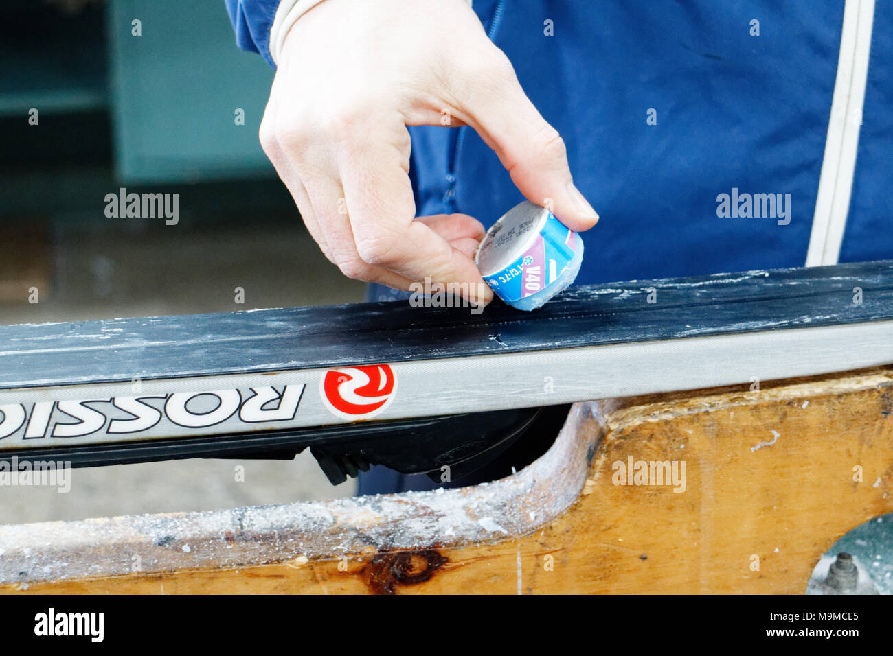 A woman waxing cross country skis before going out ski-ing Stock Photo