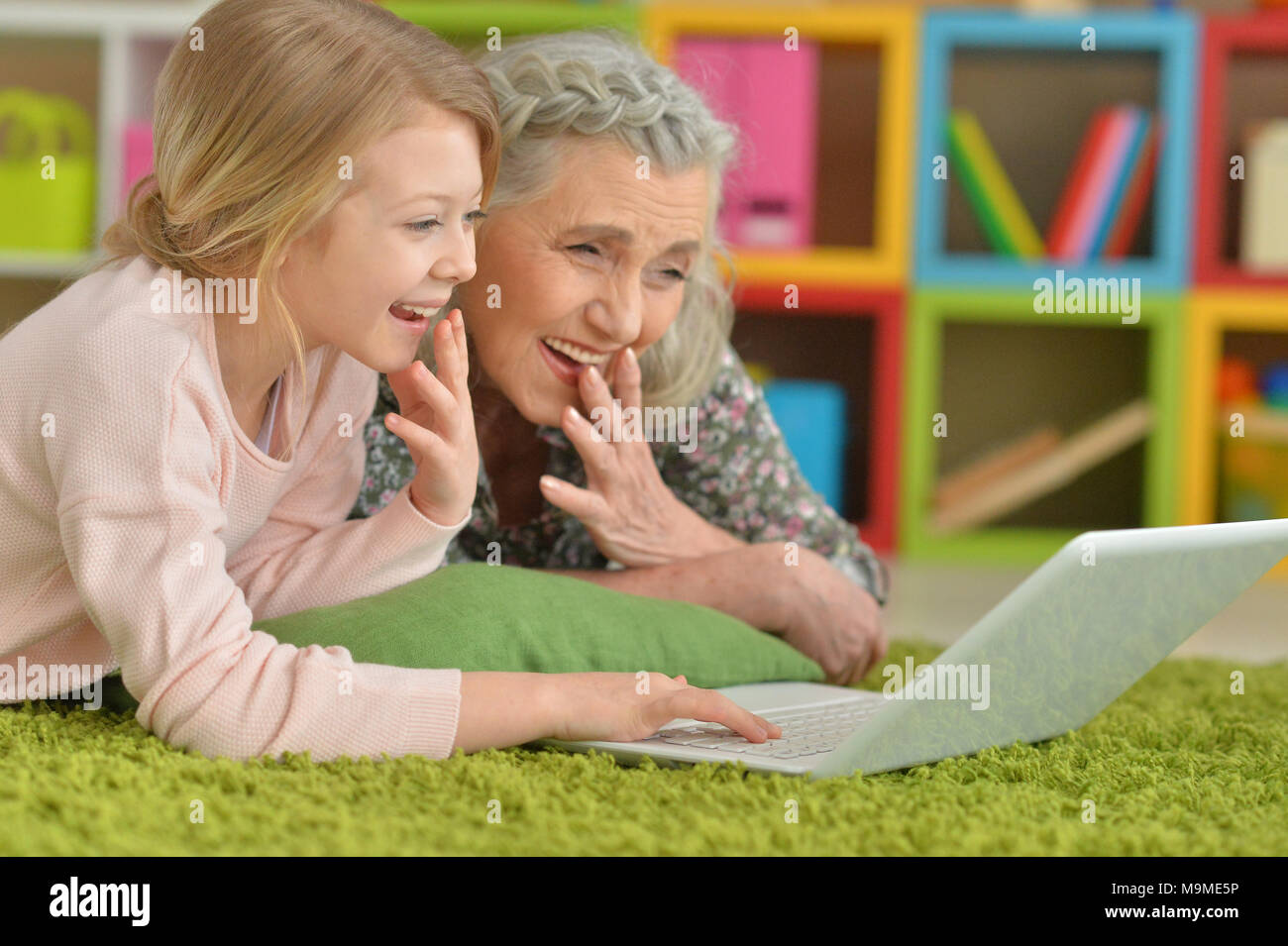 Cute little girl with her grandmother using modern laptop Stock Photo ...