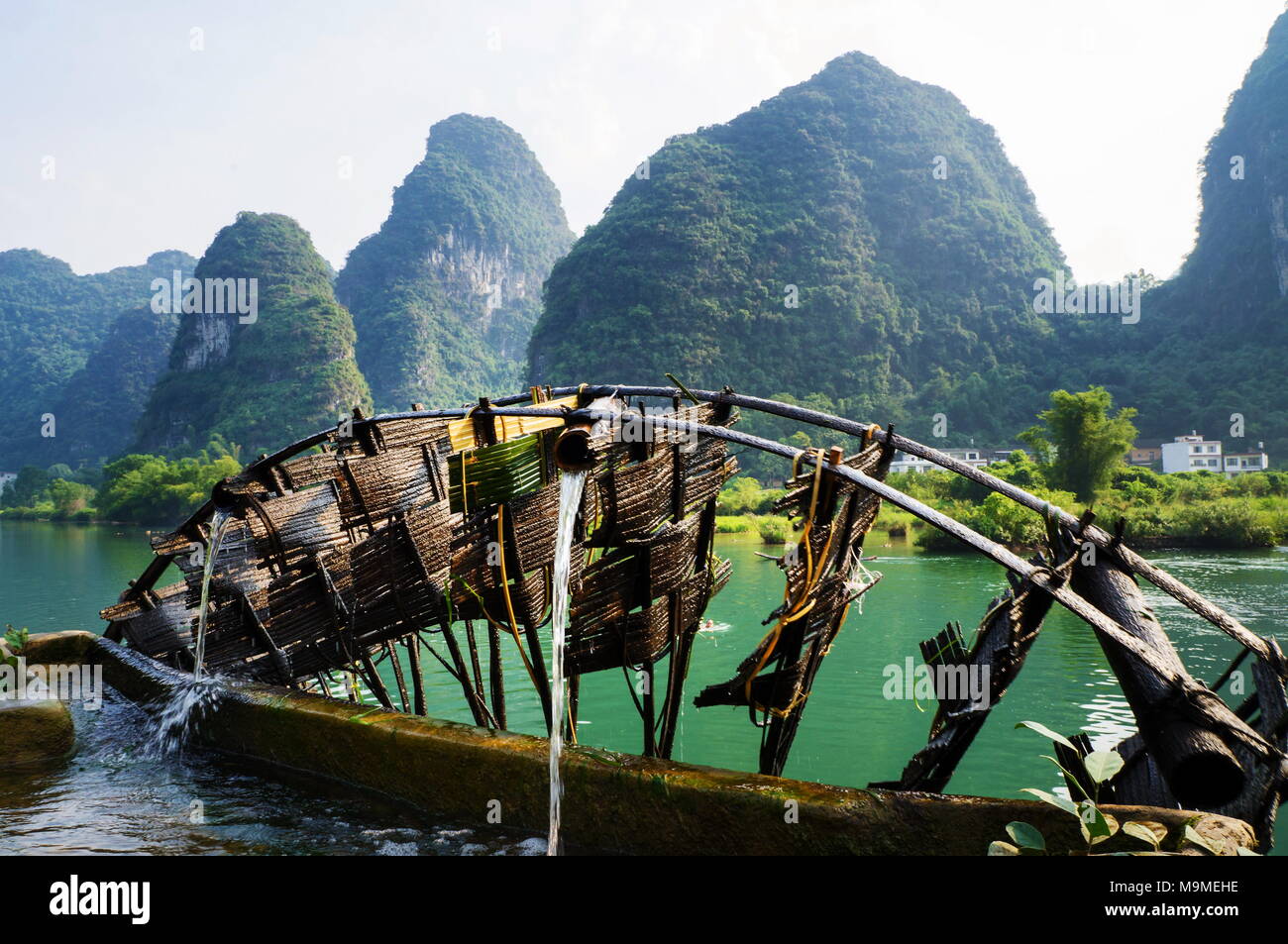 Old wooden water mill in Yangshuo Li river with karst scenery Stock Photo