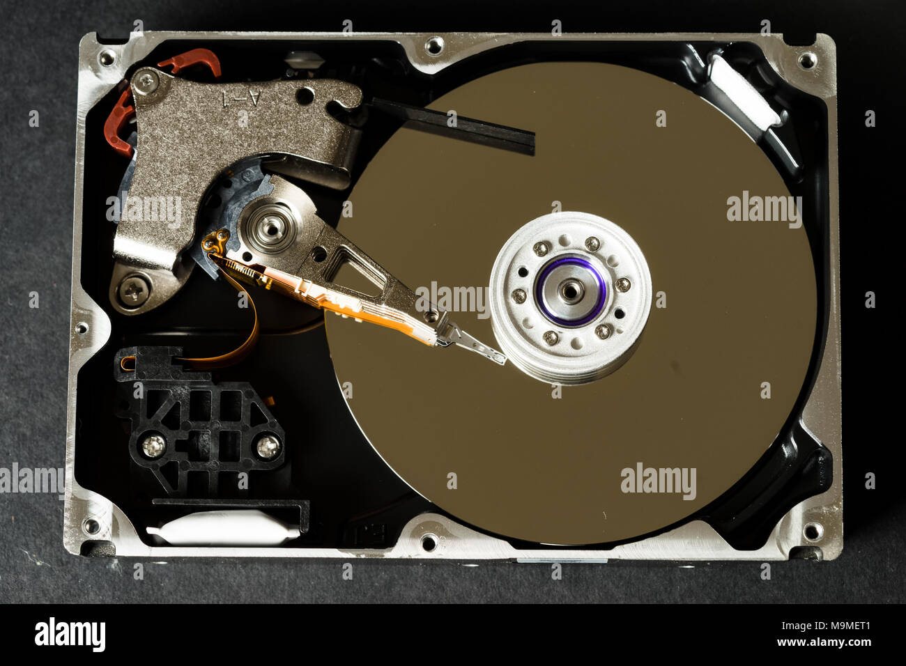 Hard disk drive with removed cover, hdd inside flat view, spindle, actuator arm, read write head, platter, ribbon cable. Stock Photo
