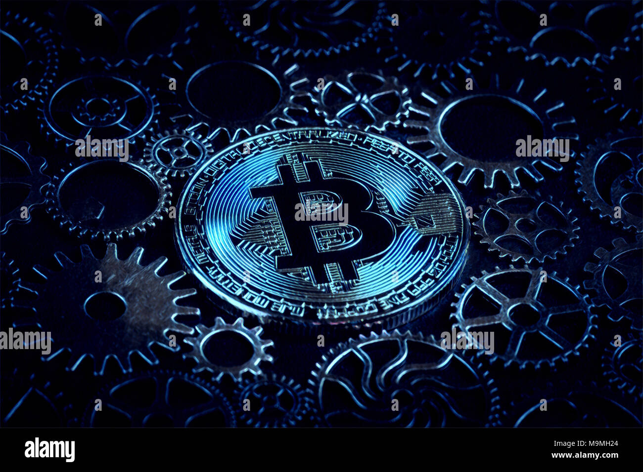 Bitcoin glowing in mysterious blue light with cog wheels digital ...