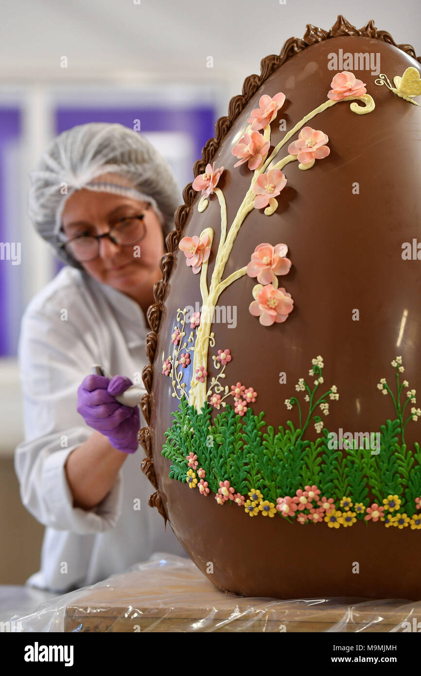 STANDALONE IMAGE Chocolatier Dawn Jenks decorates a giant chocolate egg at Cadbury World in Birmingham. Stock Photo