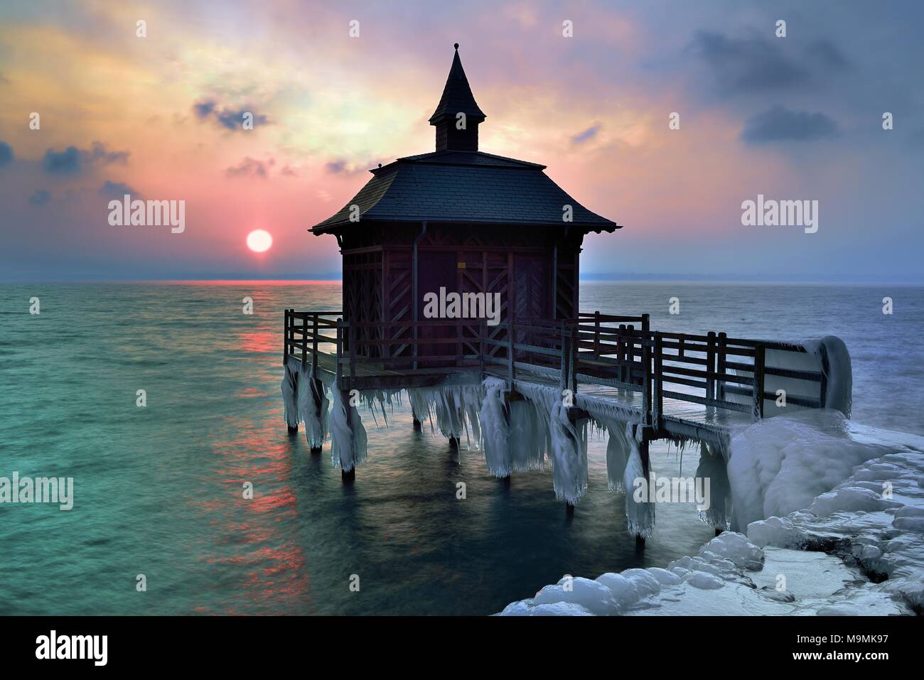 Bathhouse on pier with icicle in winter at sunrise, Lake Neuchâtel, Gorgier, Canton Neuchâtel, Switzerland Stock Photo