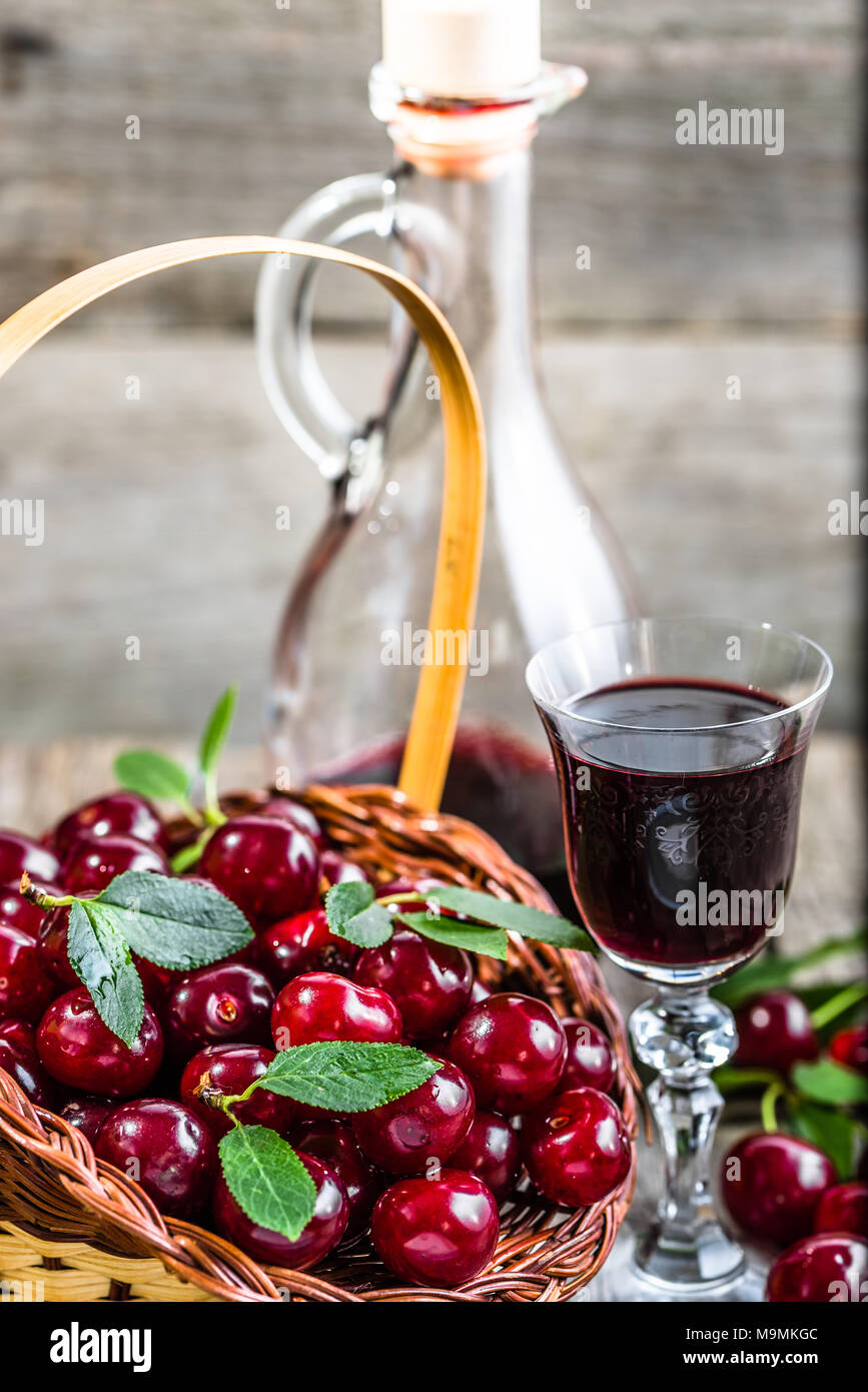 Glass of alcohol tincture made from cherry fruits, liquor in a bottle