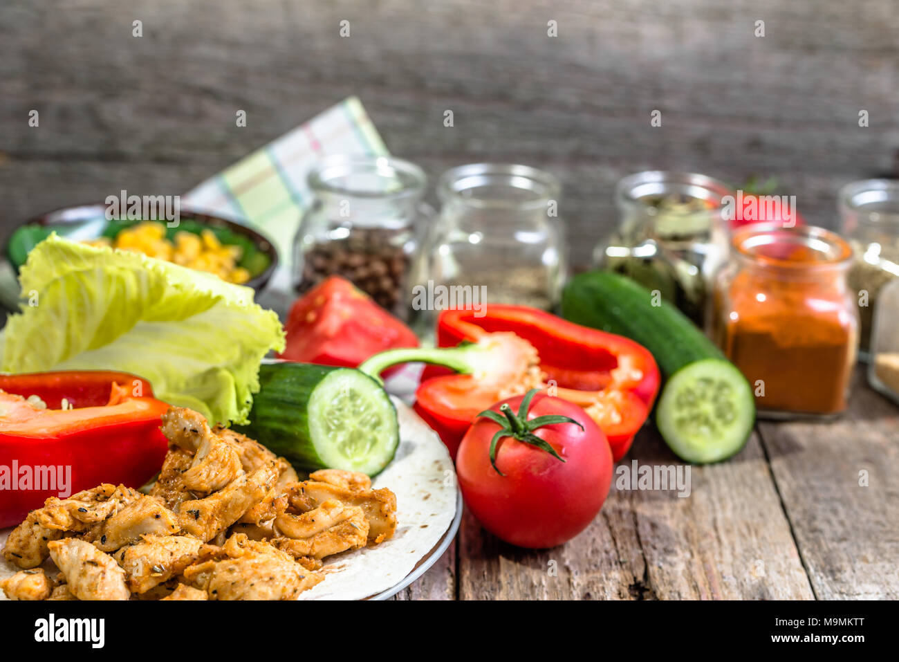 Preparing tortilla with chicken stripes and vegetables, homemade cooking recipe Stock Photo