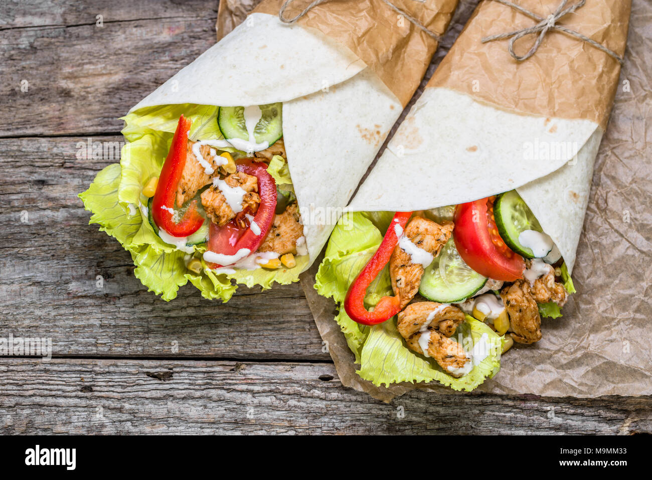 Delicious tortilla wraps with chicken and vegetables, mexican cuisine fast food, top view Stock Photo