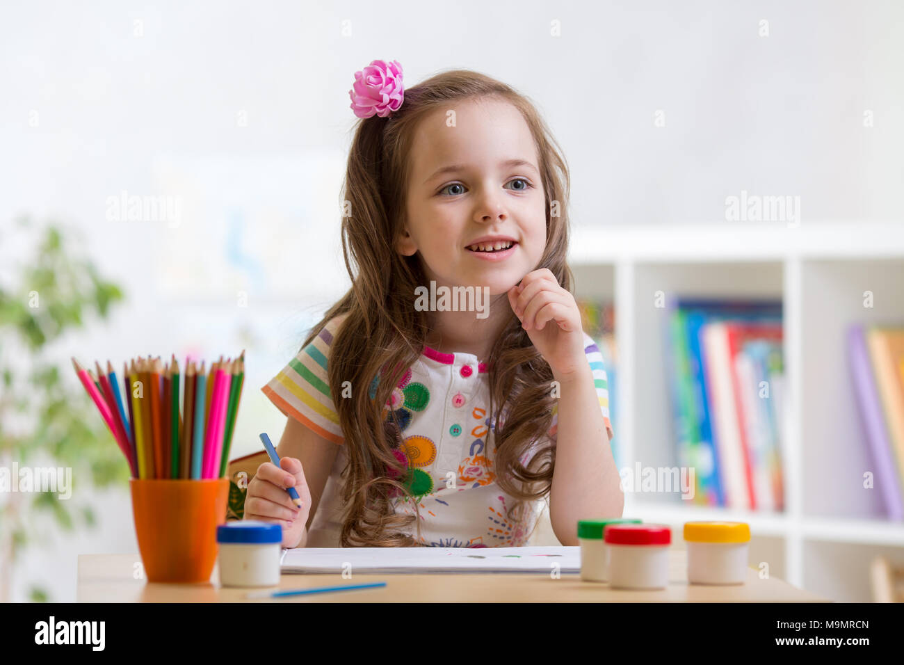 Little child girl with holding colored pencils in living room Stock ...