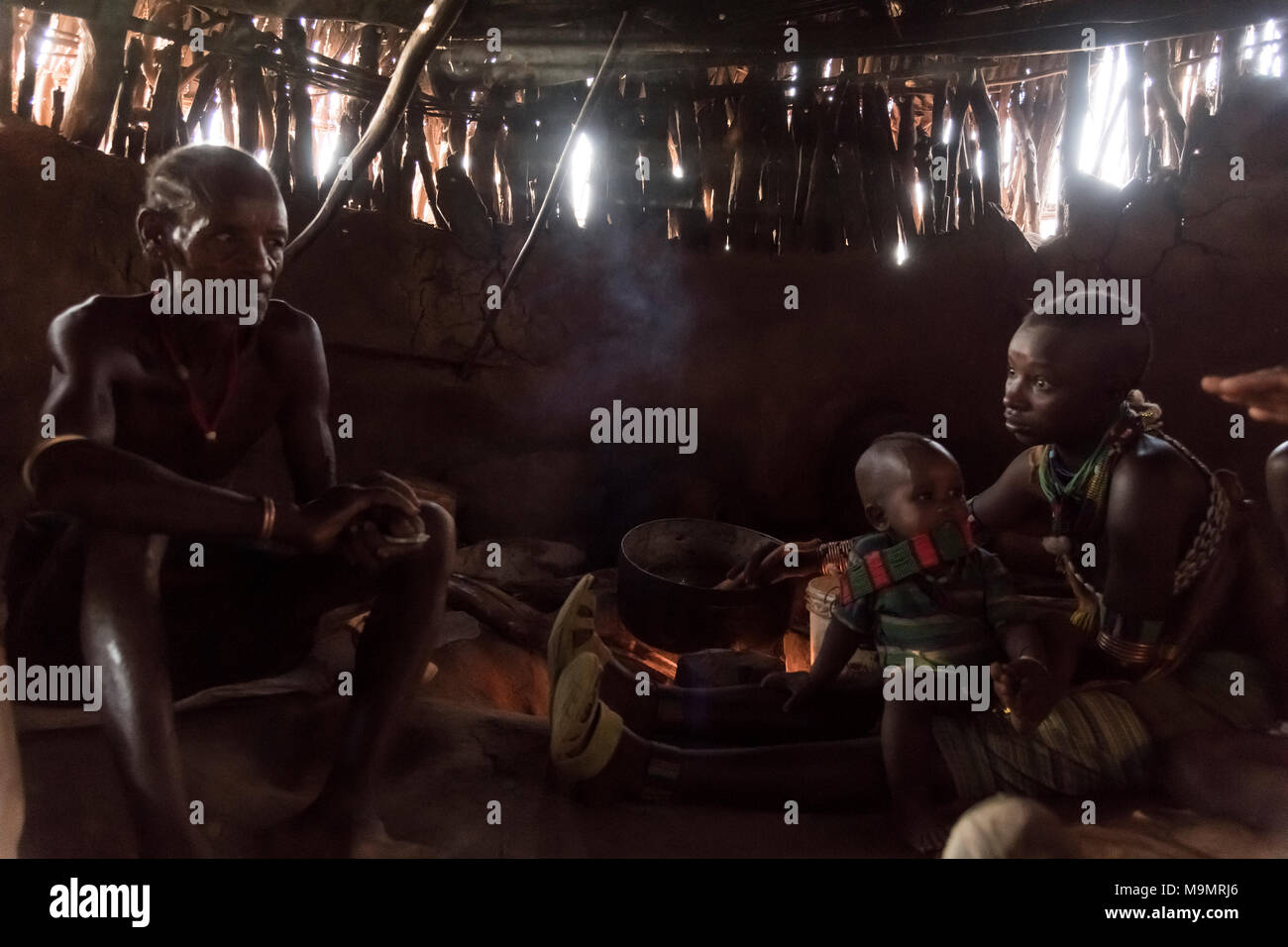 Family sits in mud hut, hamer tribe, Turmi, region of southern nations, Ethiopia Stock Photo