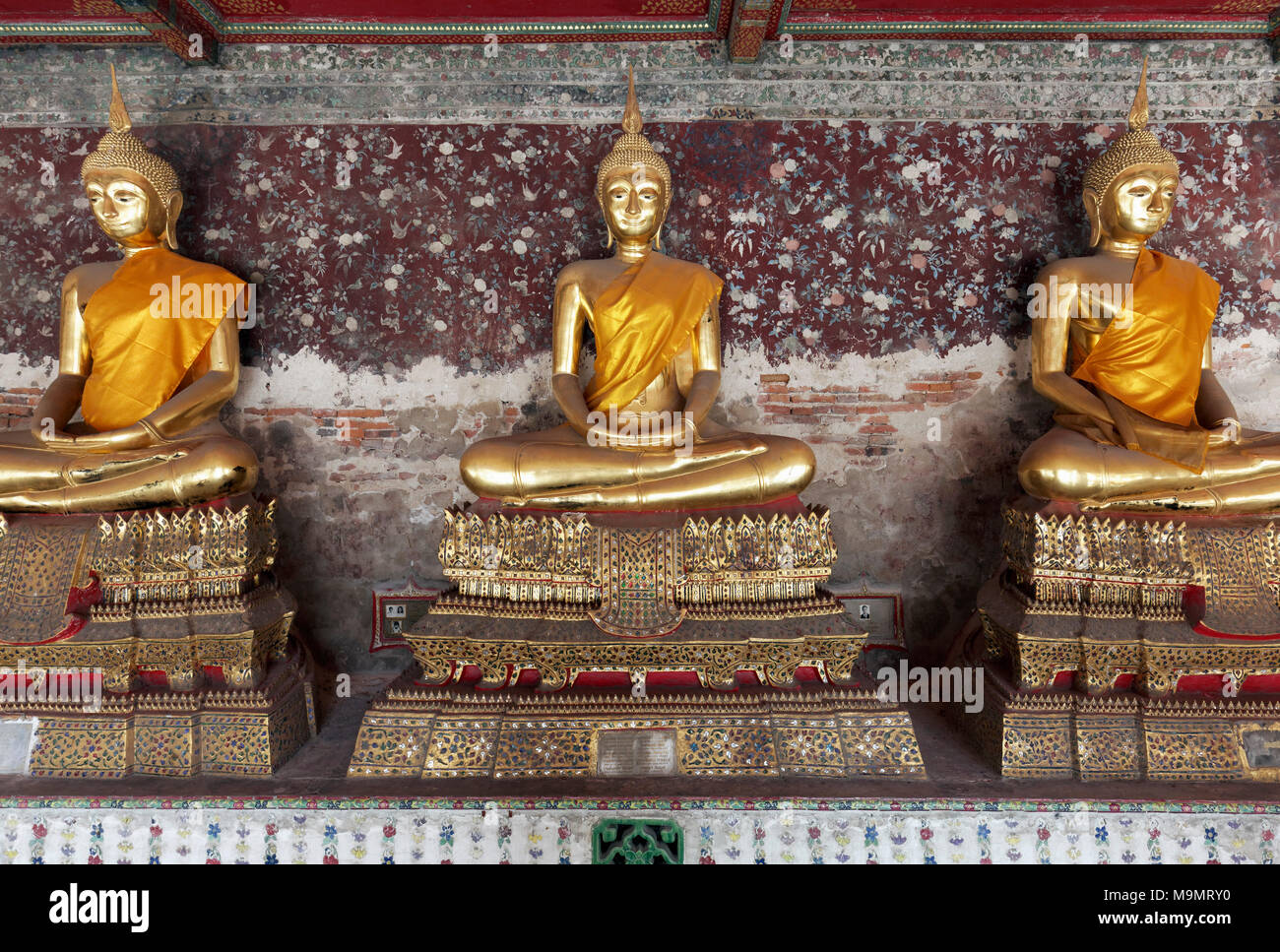 Wall with golden Buddha statues in meditation posture, on decorated pedestals, Phra Rabieng Kot, Wat Suhtat, royal temple Stock Photo