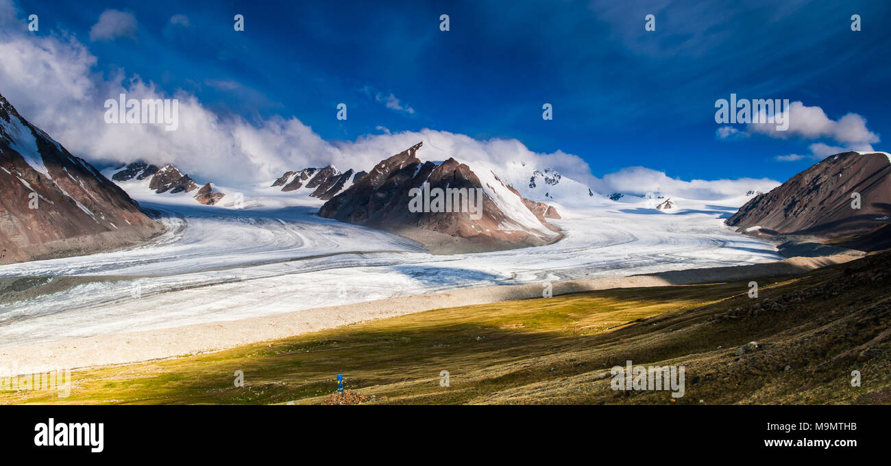 View of snow-covered Altai mountains with clouds and blue sky, Mongolia Stock Photo