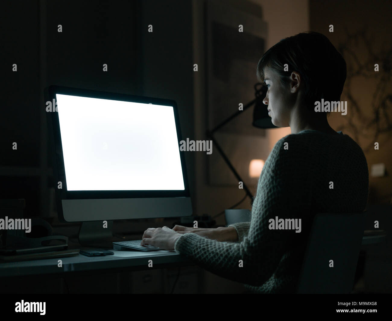 Woman working with her computer and connecting late at night, blank ...