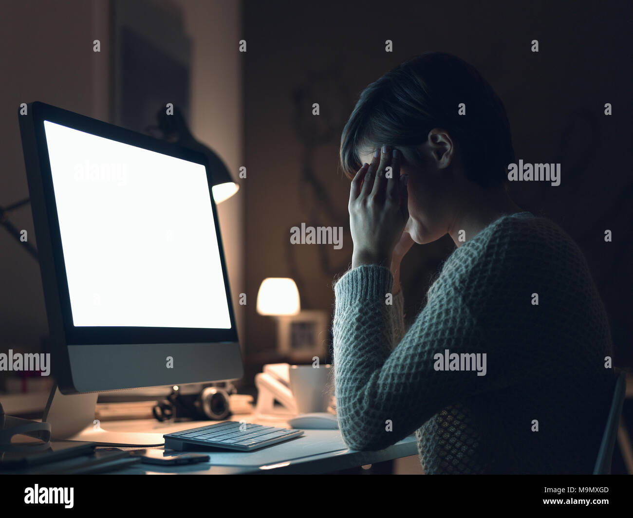 Young stressed woman working late at night with her computer and having ...