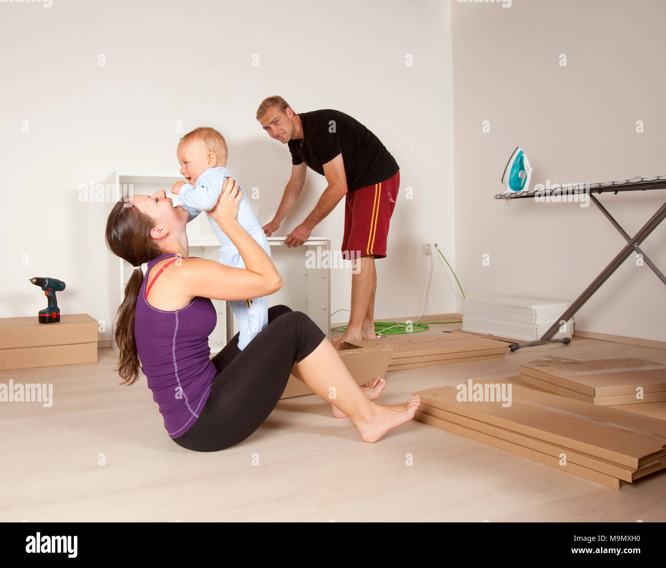 Young Family with a Baby Moving to New Flat Stock Photo