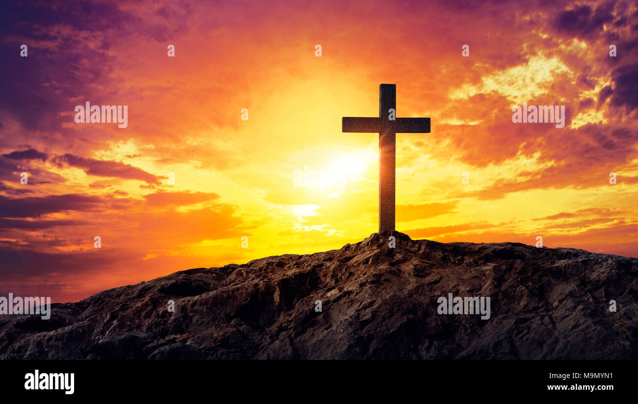 Silhouetted christian cross silhouette on the mountain at sunset Stock Photo