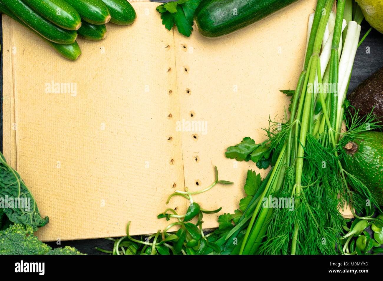 fresh green vegetables frame with notebook on a table close up Stock Photo