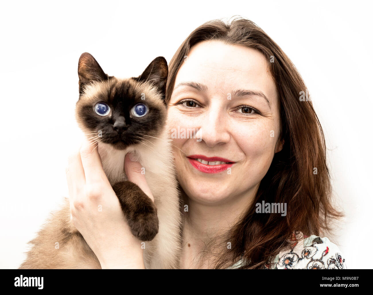 Beautiful woman with the Siamese cat in her arms smile to the camera Stock Photo Alamy