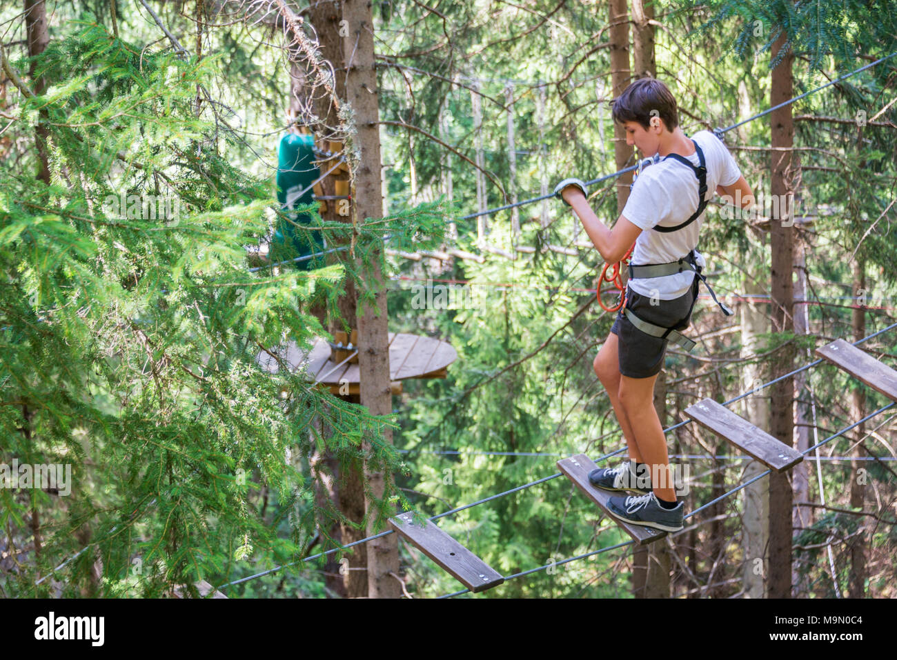 Teenager having fun on high ropes course, adventure, park, climbing