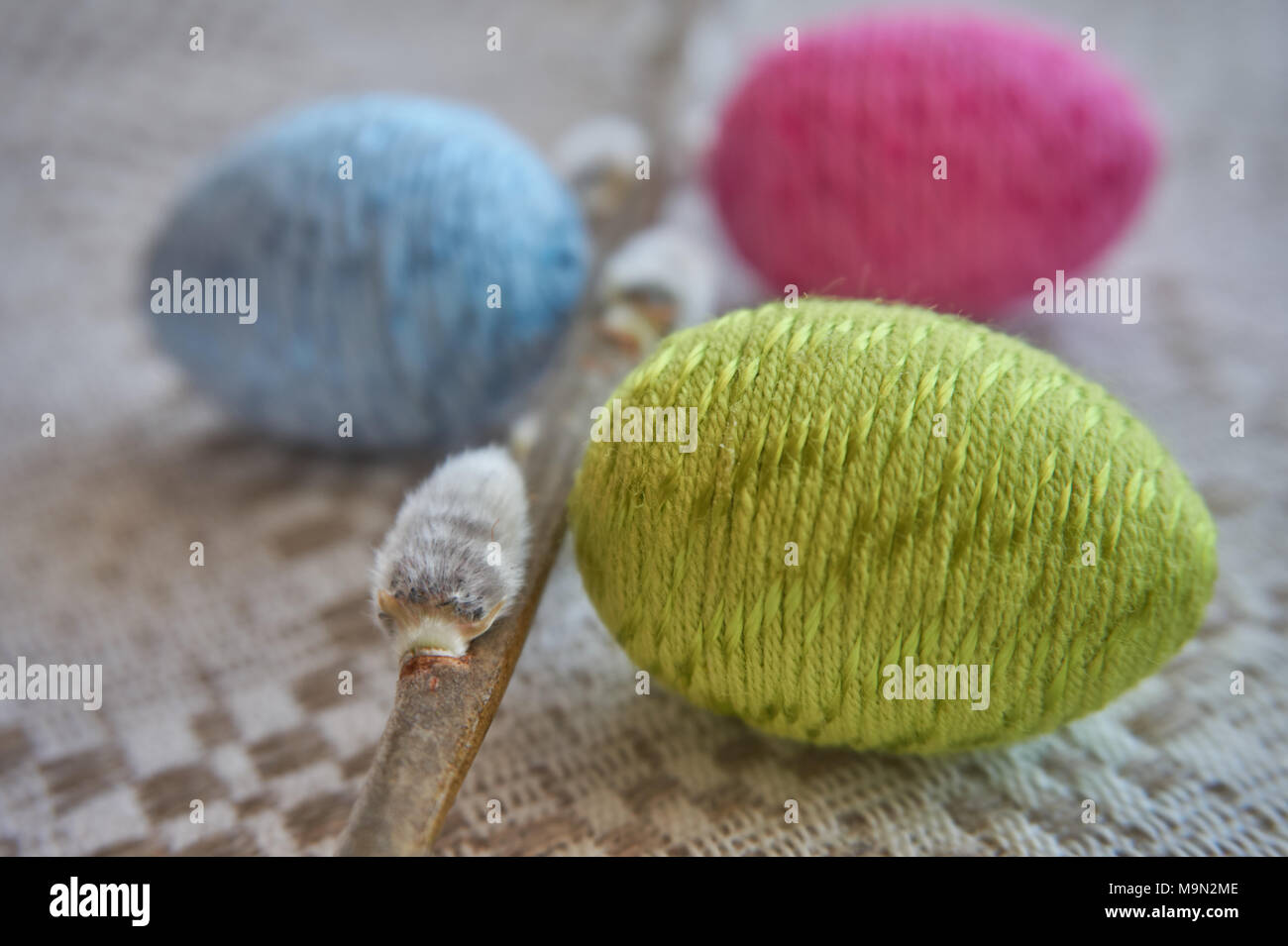 Colorful easter eggs and willow branch on a natural patterned linen tablecloth background. The concept of a happy Easter Stock Photo