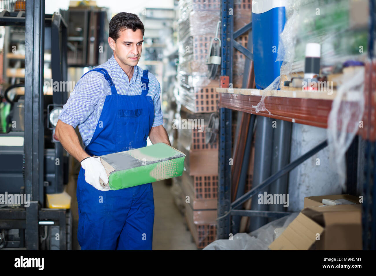 Seller male is checking bags with cement in the building store. Stock Photo