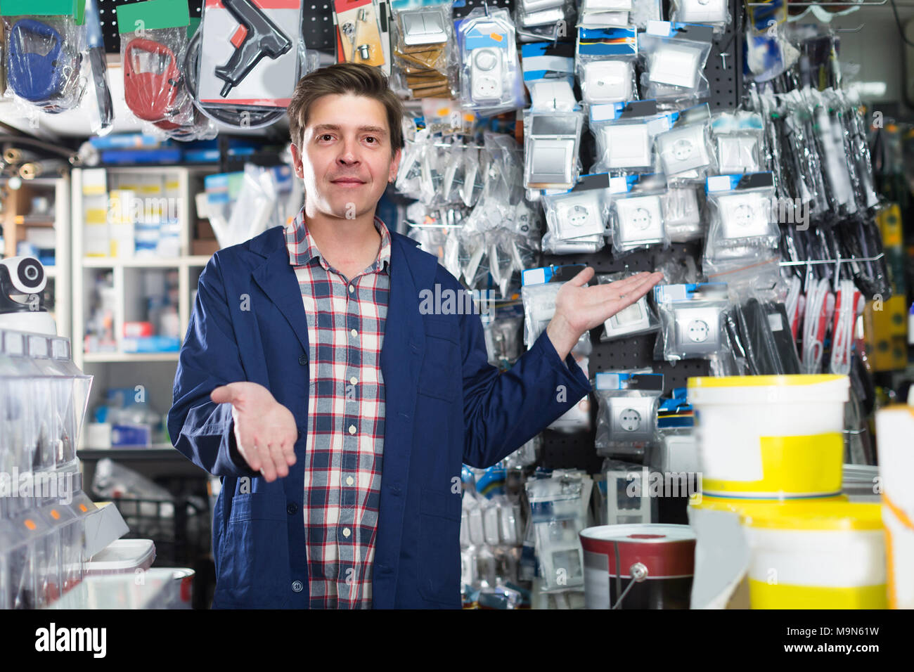 Worker man in hardware store is trading sockets and switches Stock ...