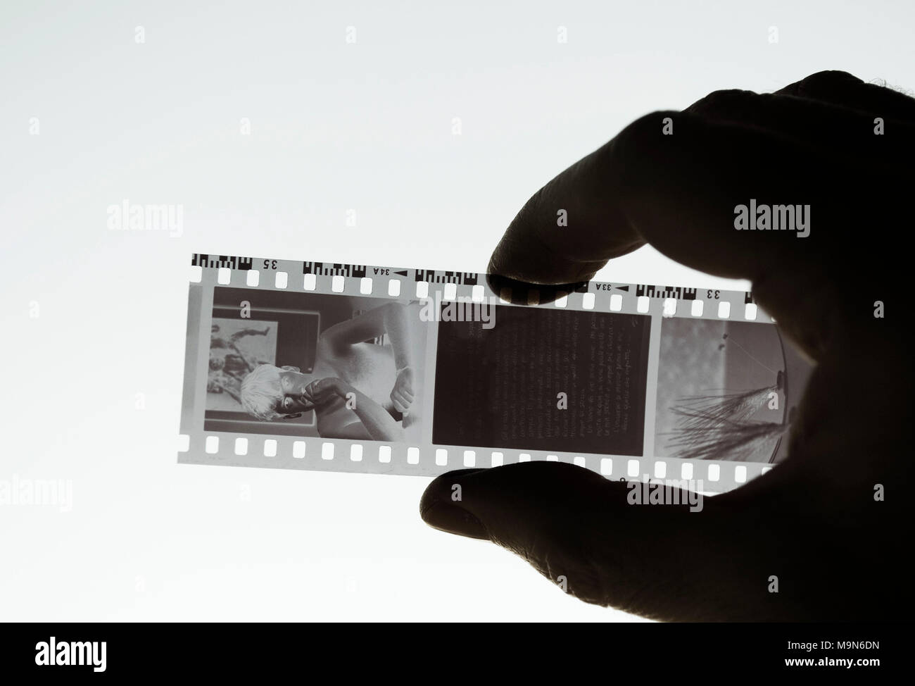 looking at a black and white negative film strip on lightbox Stock Photo