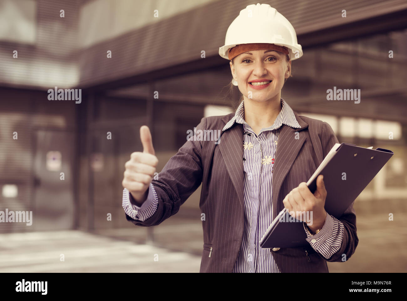 Employee woman in suit standing in helmet with paper documents Stock ...