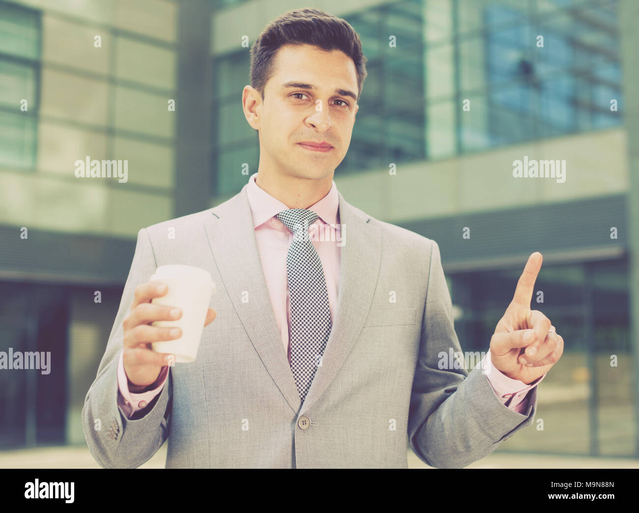 Businessman pressing imaginary button on large plant background Stock Photo