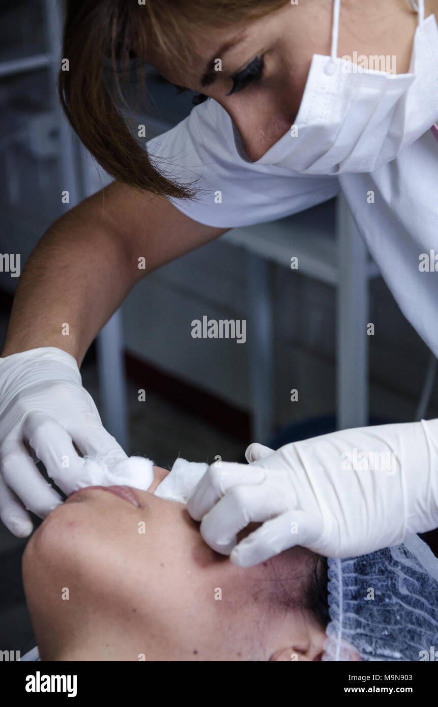 Cosmiatra performing facial cleansing on a patient Stock Photo