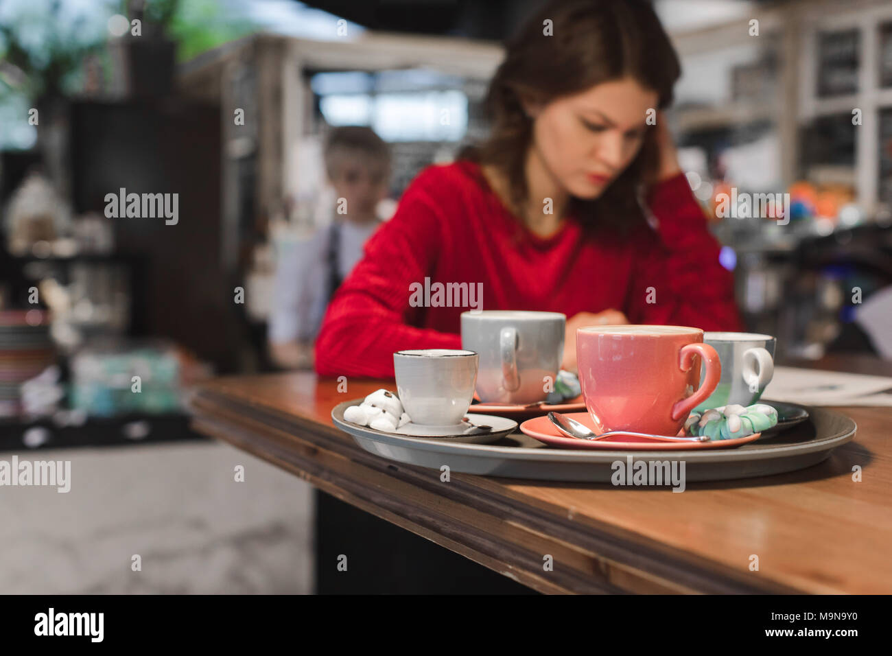 Assortment of cups with coffee drinks on the background of a busy girl Stock Photo