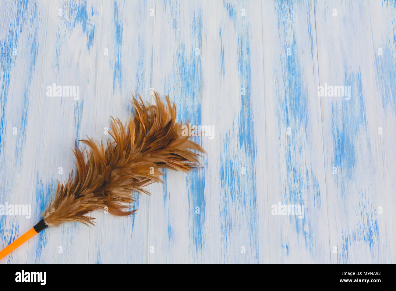Feather duster for clean the dust on wooden background and copy space for insert text Stock