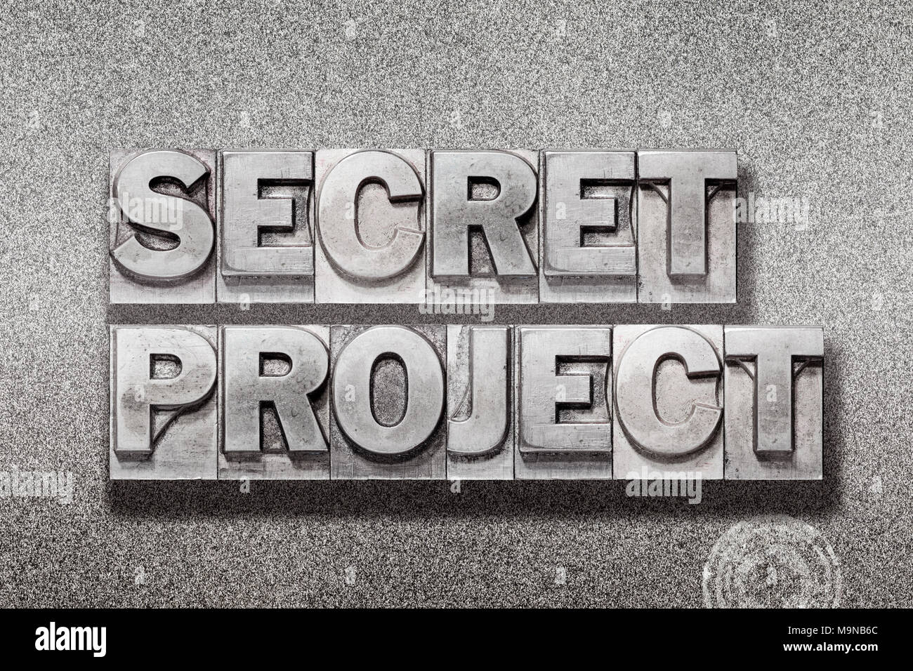 secret project phrase made from vintage letterpress on metallic textured background Stock Photo
