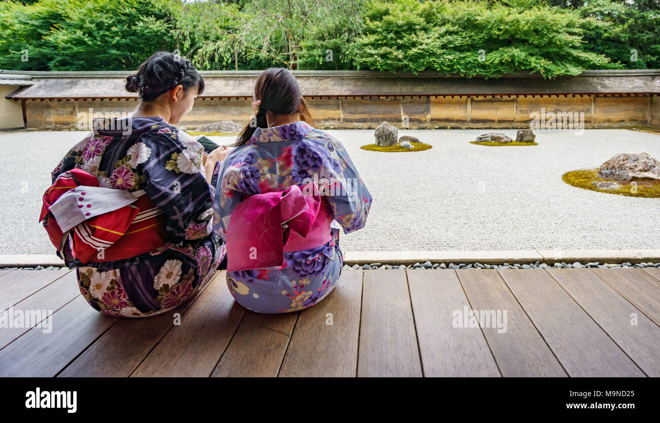 KYOTO, JAPAN - JUNE 7: Unidentified women dress in traditional clothes and observe Japanese typical zen garden in Kyoto on June 7, 2015 in Japan Stock Photo