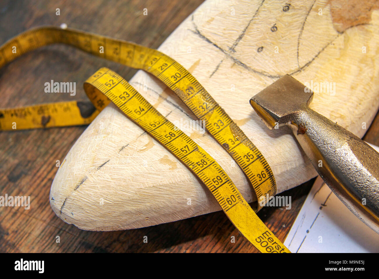 Wooden reads with a measuring tape and tools at a skilled shoe maker in Holland. Stock Photo