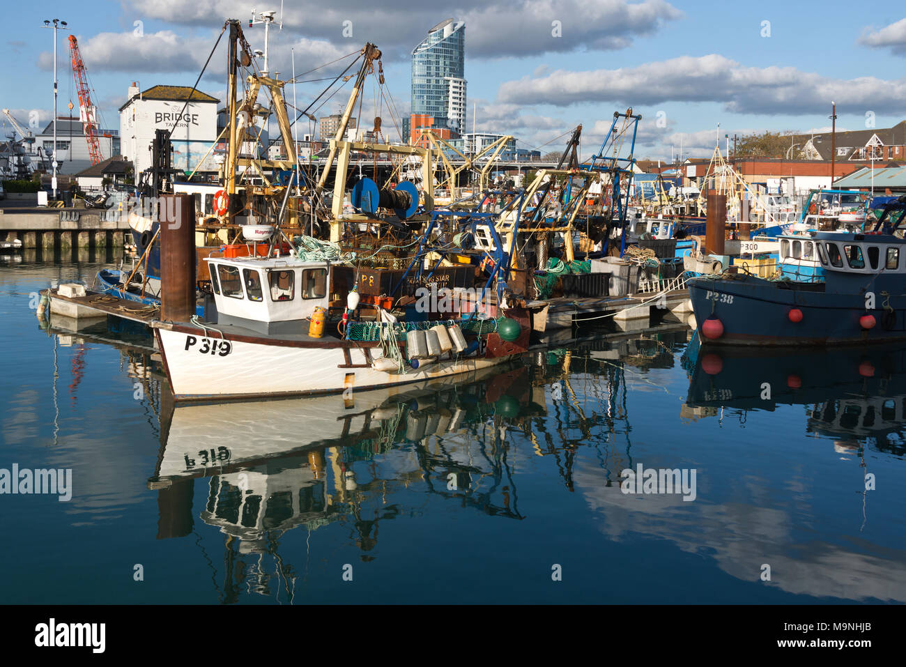 Fishing boats and their reflections while at their moorings in Camber