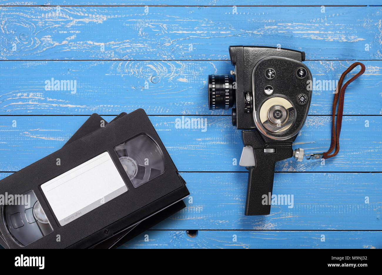 Vintage portable movie film camera Videotapes VHS on a blue wooden background. Stock Photo
