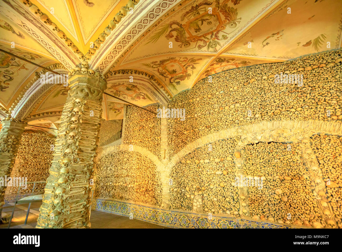Evora, Portugal - August 18, 2017: Chapel of Bones or Capela dos Ossos, one of most visited monuments of Evora. Walls and columns adorned with human bones and skulls. Mortuary-themed painted ceiling. Stock Photo