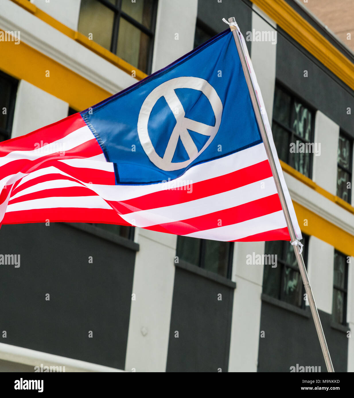 An American flag designed with a peace symbol flies during the March For Our Lives protests in Houston Stock Photo