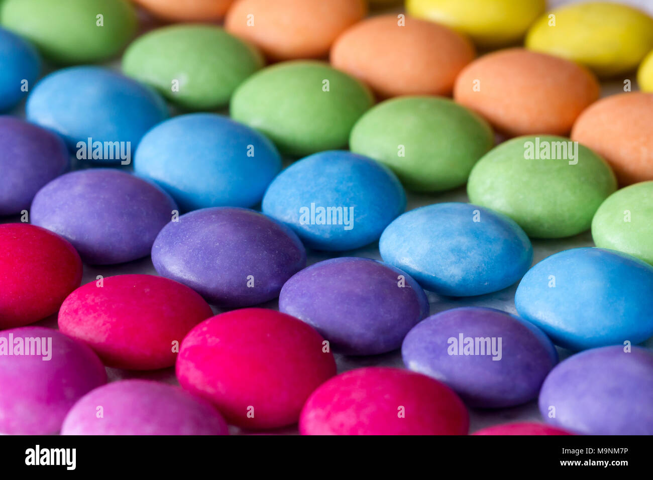 Rows of coloured sweets, smarties Stock Photo