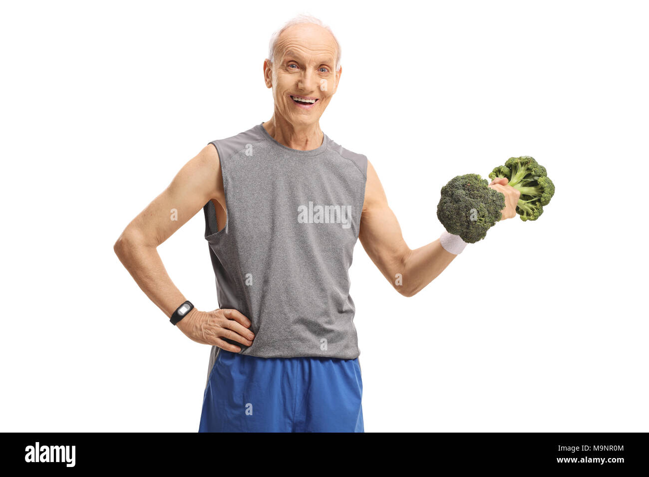 Elderly man holding a broccoli dumbbell and smiling isolated on white background Stock Photo
