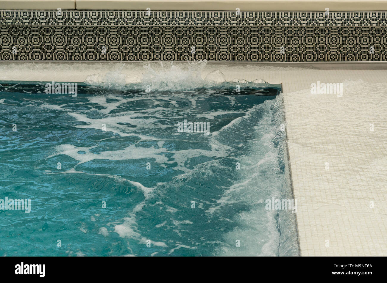 Water sloshing around tiled swimming pool on cruise ship Stock Photo